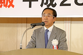 あいさつする冨田会長