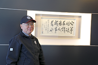 180508top4 海藤社長と社名の由来である漢詩の一節。「甲等碌々、所謂因人、成事者也」(こうらろくろく いわゆるひとによりて ことをなすものなり)。個人の力と個性が集結し、刺激し合い初めて大きな力と成り得る、との意味がある。