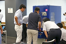 170814top5 ロボットを採用したバリ取りを真剣に見学する参加者。バリ取りの自動化は加工現場の無駄を省く